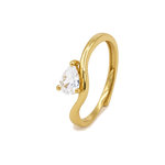 Anello con pietra a goccia, finitura dorata e pietra chiara, sfondo beige